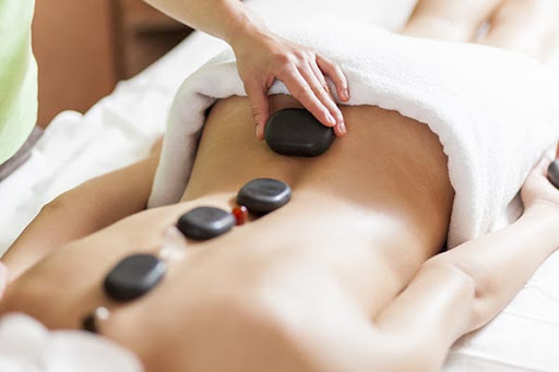 Young woman having a hot stone massage therapy|cheque cadeau pierres chaudes 1h30|massage pierre chaude 3COMPRESSEE2 ||